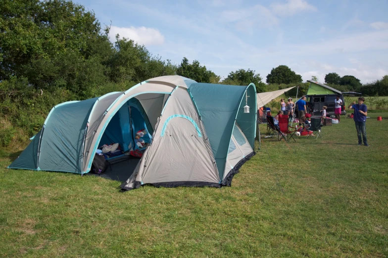 people are camping in a field with tents