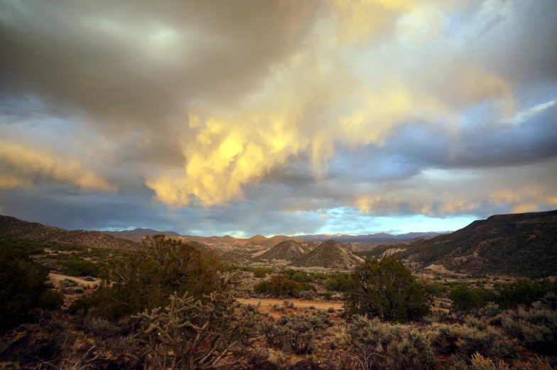 a bunch of clouds loom above the desert