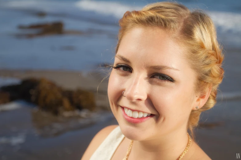 a woman standing near the ocean smiling at soing