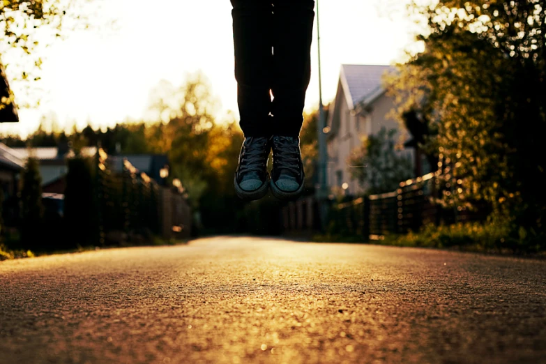 a person leaping up in the air on a road