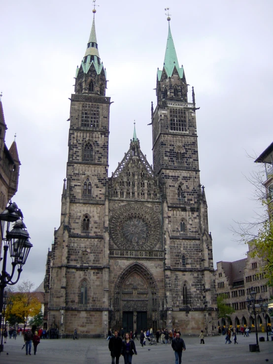 large old stone building with two towers in a town square