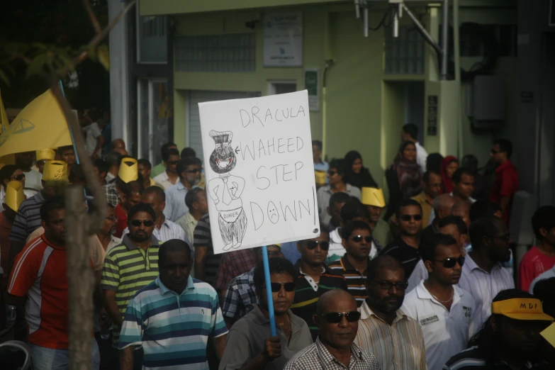 a crowd with a protest sign and a few men