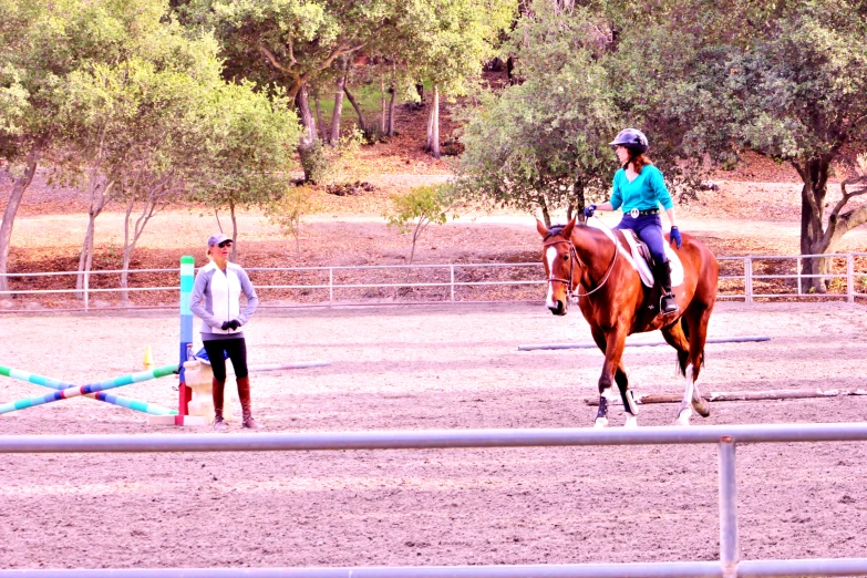 a horse is trotting in the dirt near two people