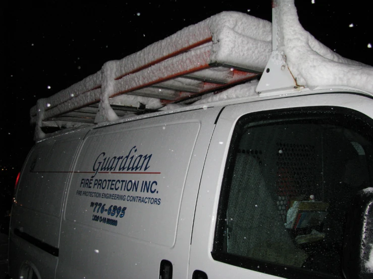 a snow covered white van with a deck