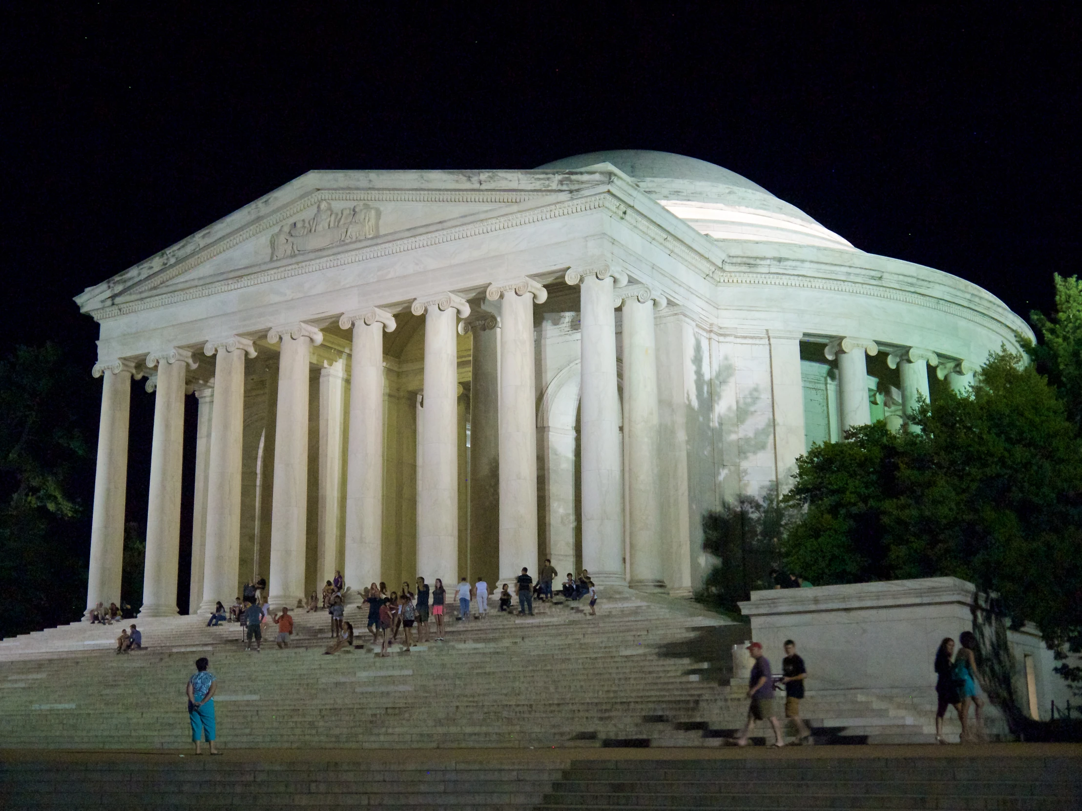 people stand on the stairs near the building