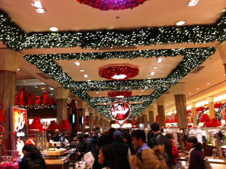 inside of an indoor market, many people shopping and walking