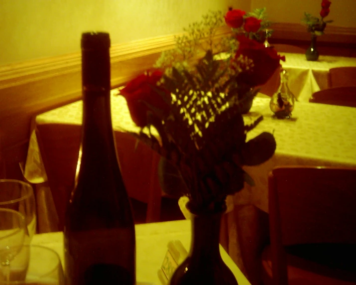 a table topped with wine glasses and vases filled with flowers