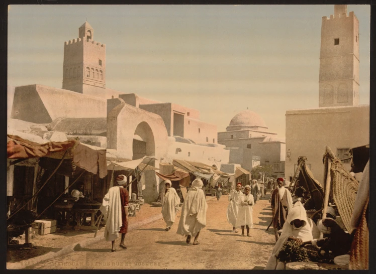 people walk around in the desert village on a sunny day