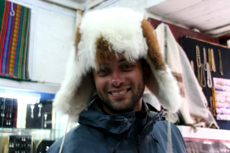 man wearing a furry hat while smiling for a po