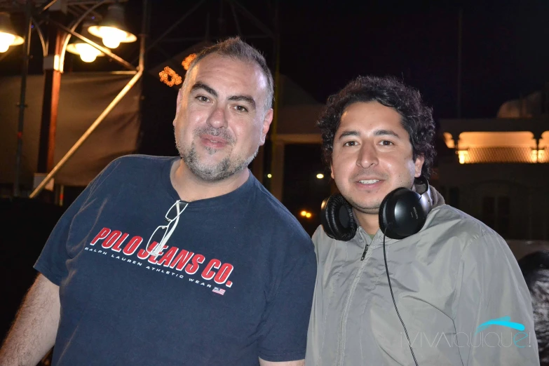 two men standing next to each other in front of a building