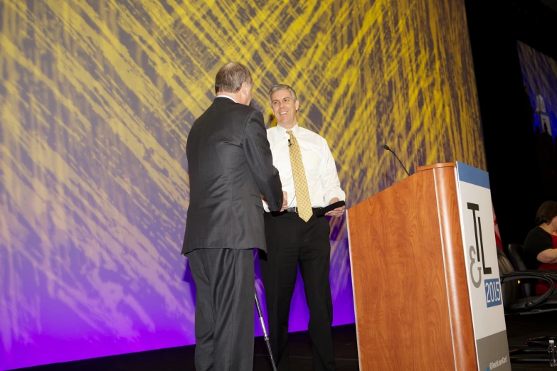 two men talking at the lecters during an event