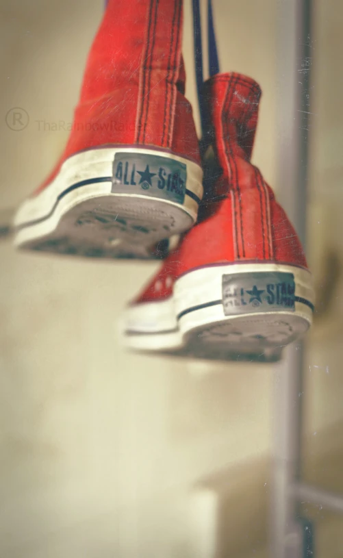 red sneakers that are hanging from a pole