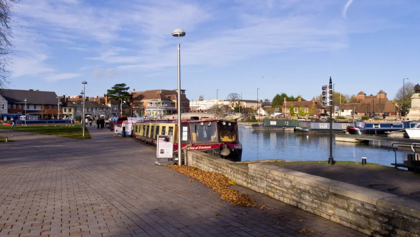 a long tour boat is parked next to a river