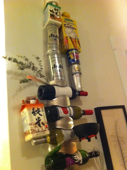 there are many different bottles of alcohol stacked on a wall