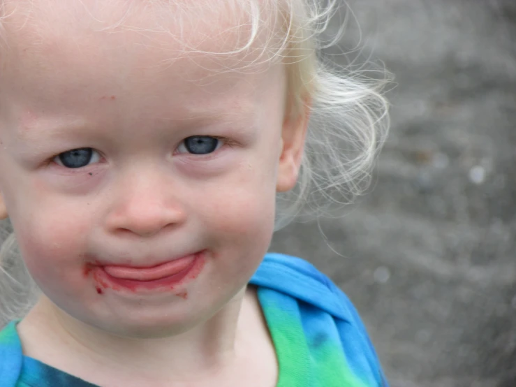 small child with hair all over his face smiling