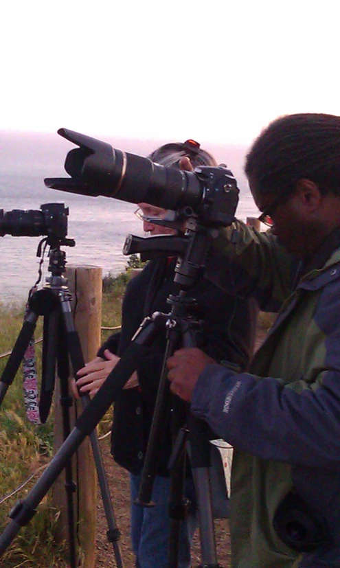 people looking at the ocean from a hilltop