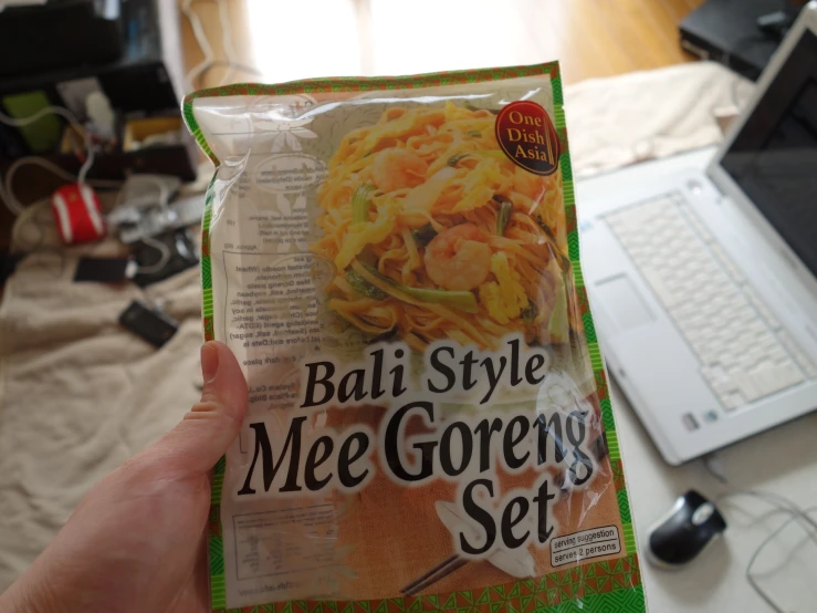 a person holding up a bag of mac and cheese noodles