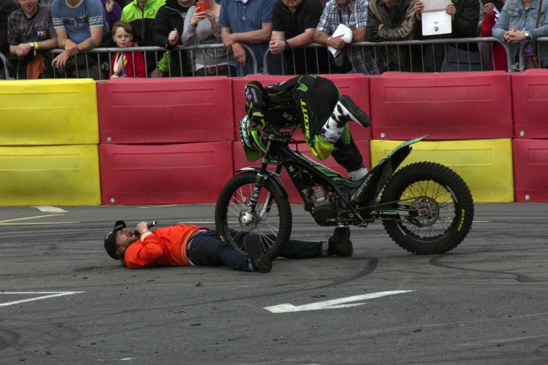 a man laying down on the ground next to a motorcycle