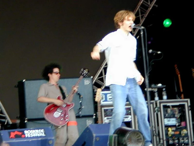 a man standing next to another person on a stage