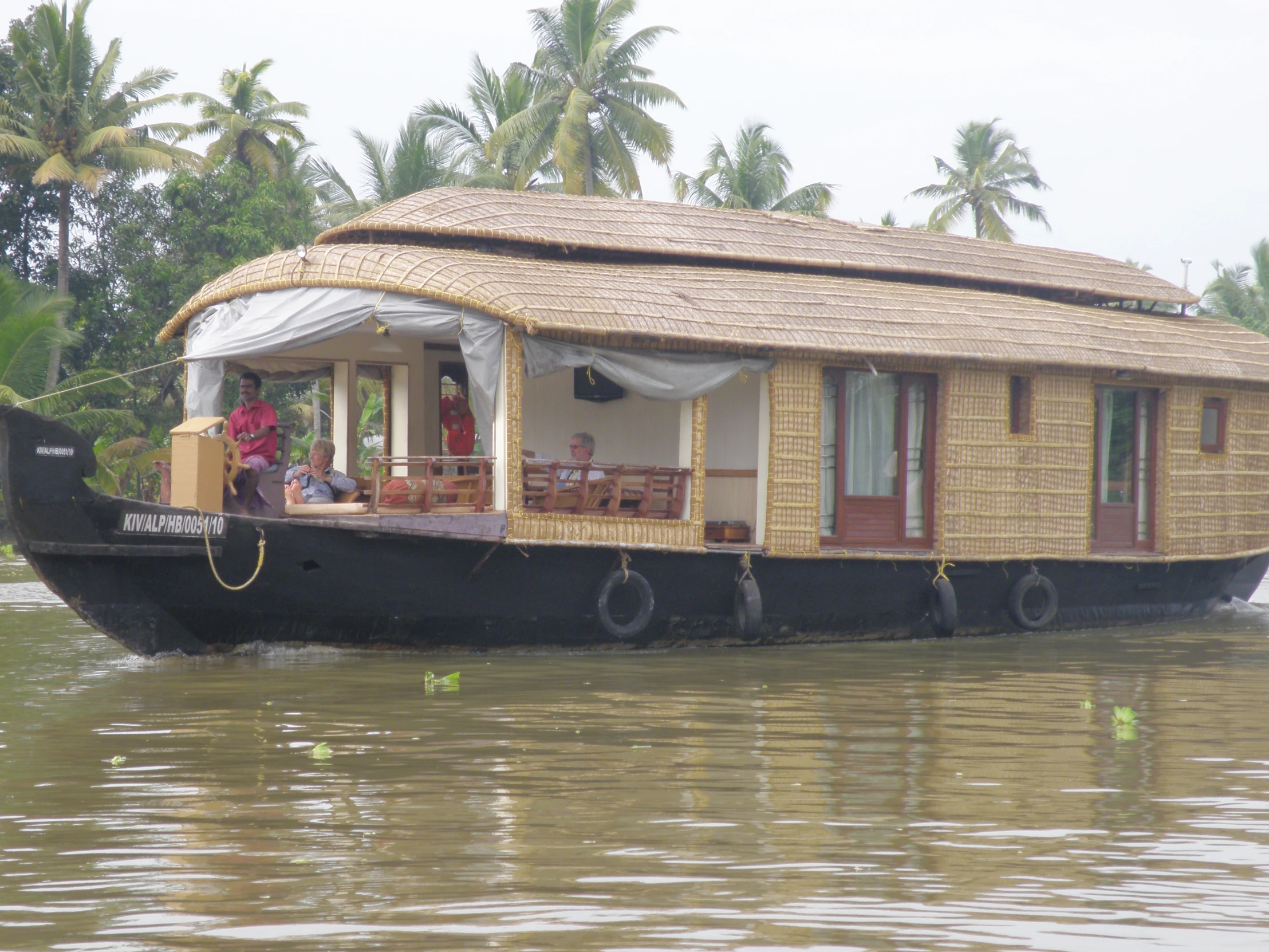 two people are in the open houseboat on a river