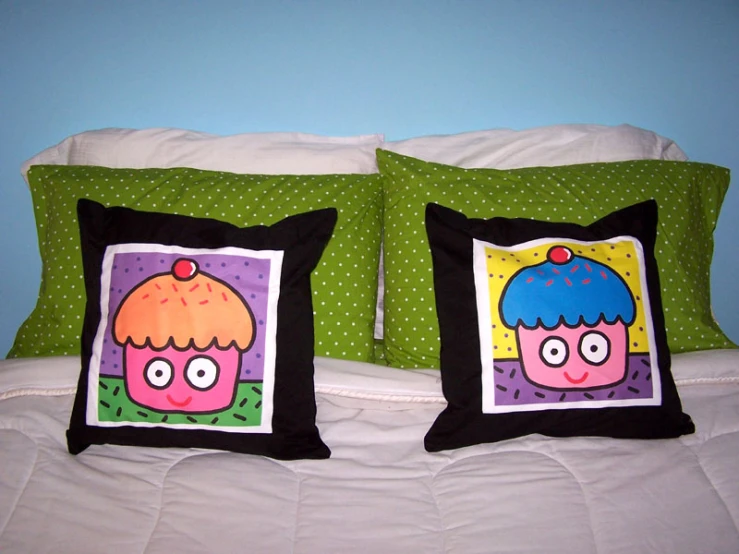 two pillows with pictures of two cute cartoon characters on them