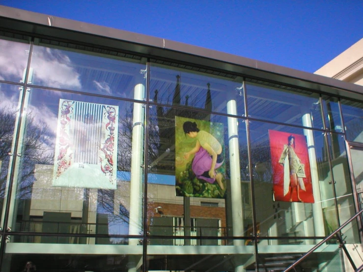 a building with large windows with some people walking by