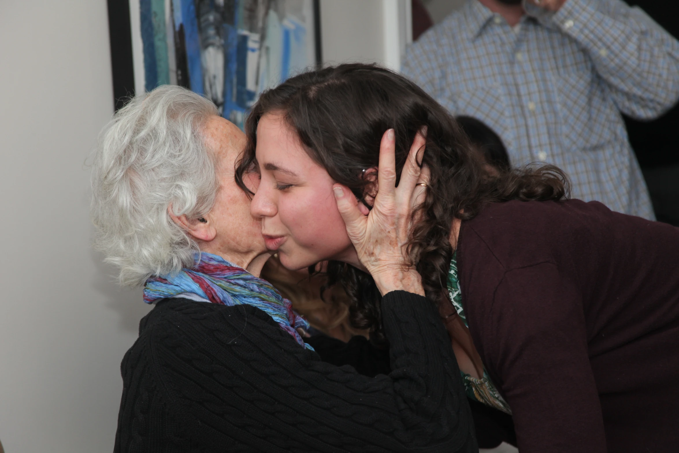 a woman with her eyes closed is kissing an older womens face