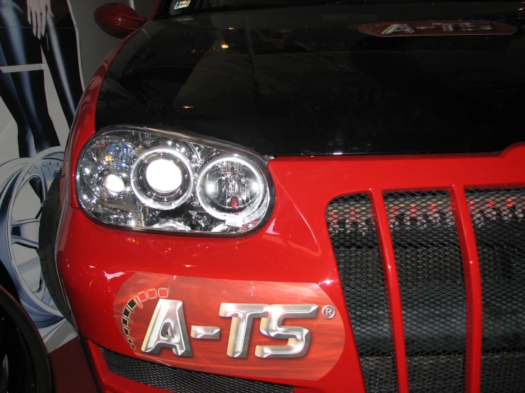 the front bumper of a red car with the at5 logo