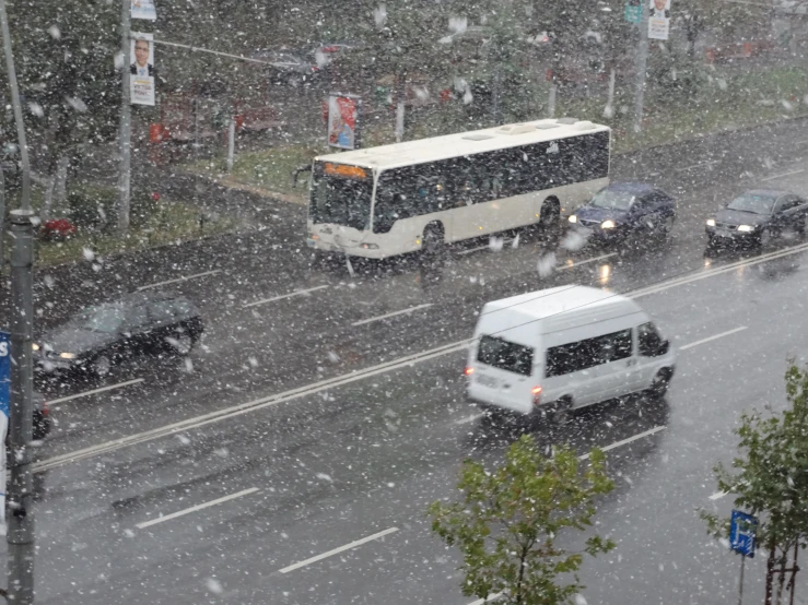 two busses passing by on a street on a snowy day