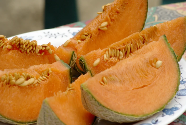 a plate of sliced watermelon on a floral print cloth