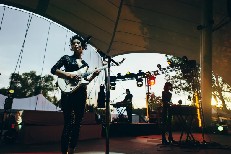 a woman on stage playing an electric guitar