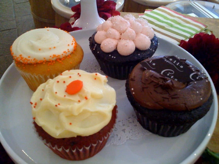 there are four decorated cupcakes on this plate