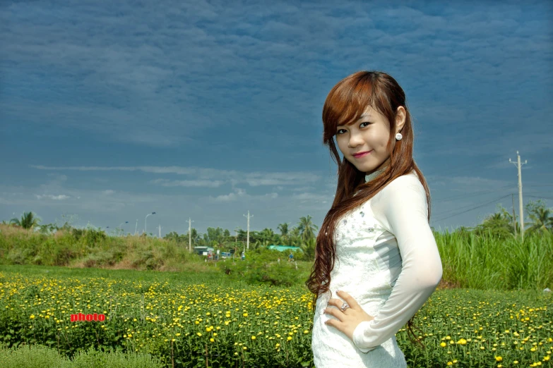 a woman standing in the grass with her arms crossed