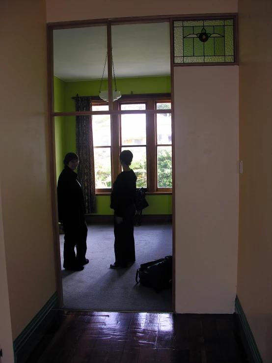 two people standing in front of a doorway