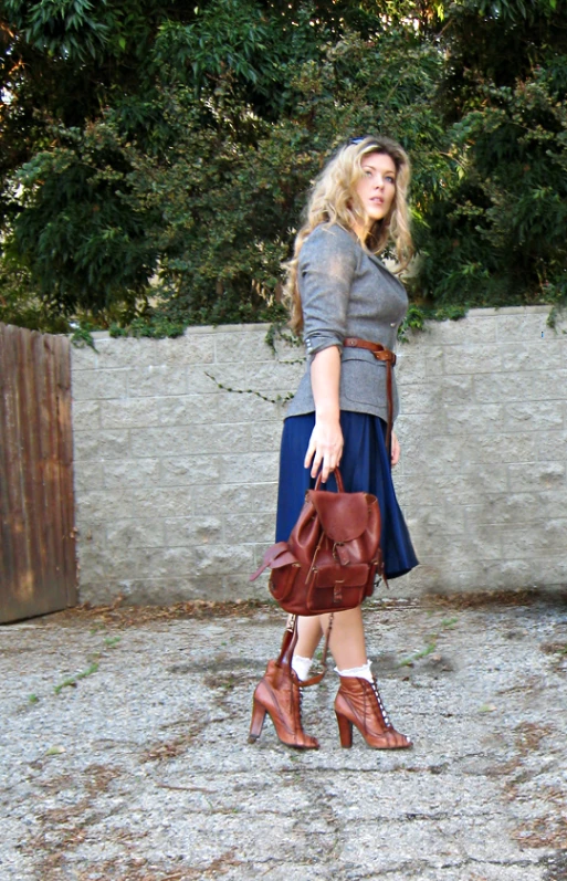 a woman carrying a brown purse and a tan handbag