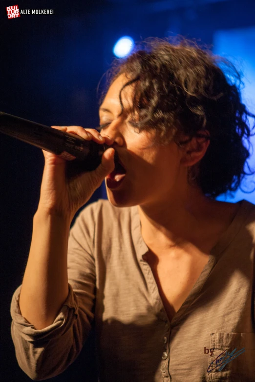 a person that is holding a microphone to their mouth