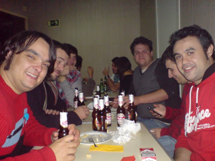 a bunch of people sitting at a table with beer in front of them