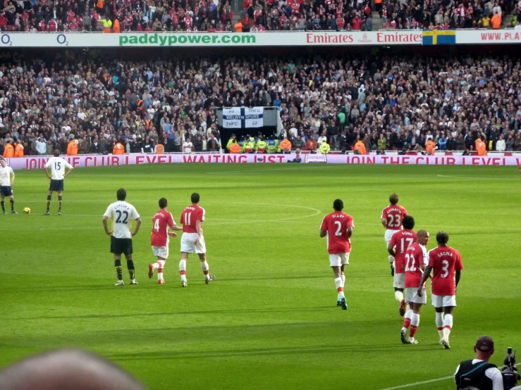 a crowd is watching two soccer teams on a field