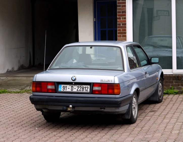 the old car is parked on a street in front of the house