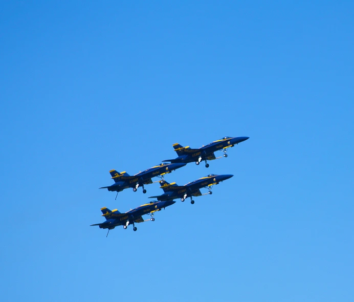 the four planes are flying through the blue sky