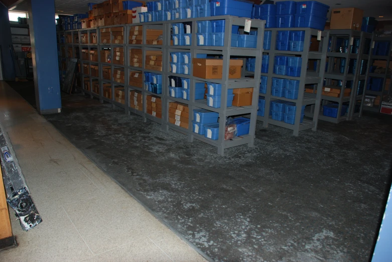 a warehouse filled with shelves with blue and orange boxes