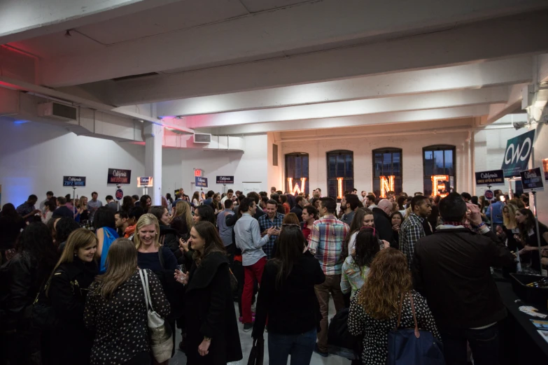 a crowd of people inside of a white building