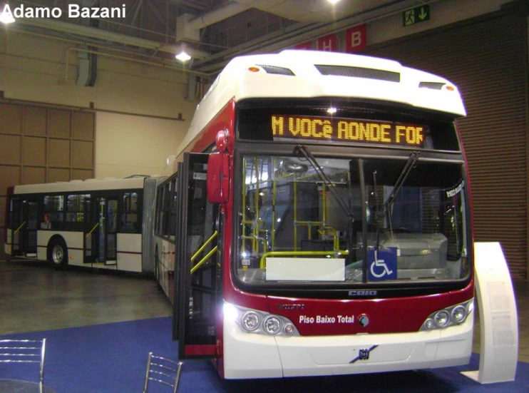 two buses in an open building with blue and red carpet
