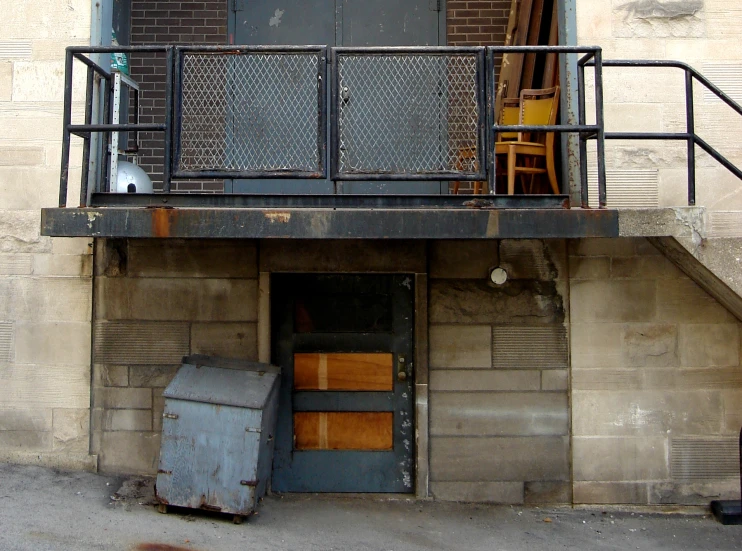 the back of a building with a bunch of crates in the doorway