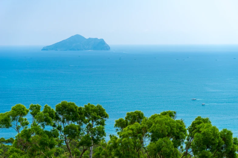 several boats are out on the water near an island