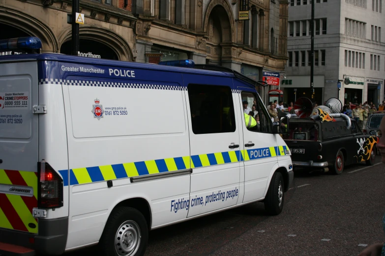 an ambulance with bright yellow and blue stripes parked next to a police car