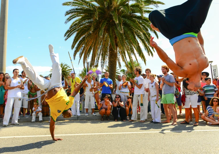 two men doing handstands while people watch