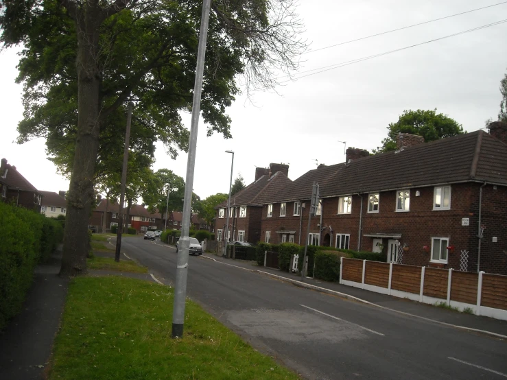 a street scene looking toward brick homes and green fields