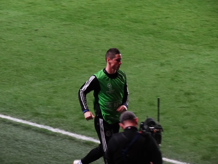 a soccer player running across the field in the grass