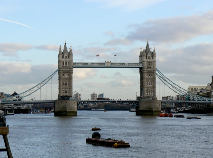 the boats on the river are near the bridge